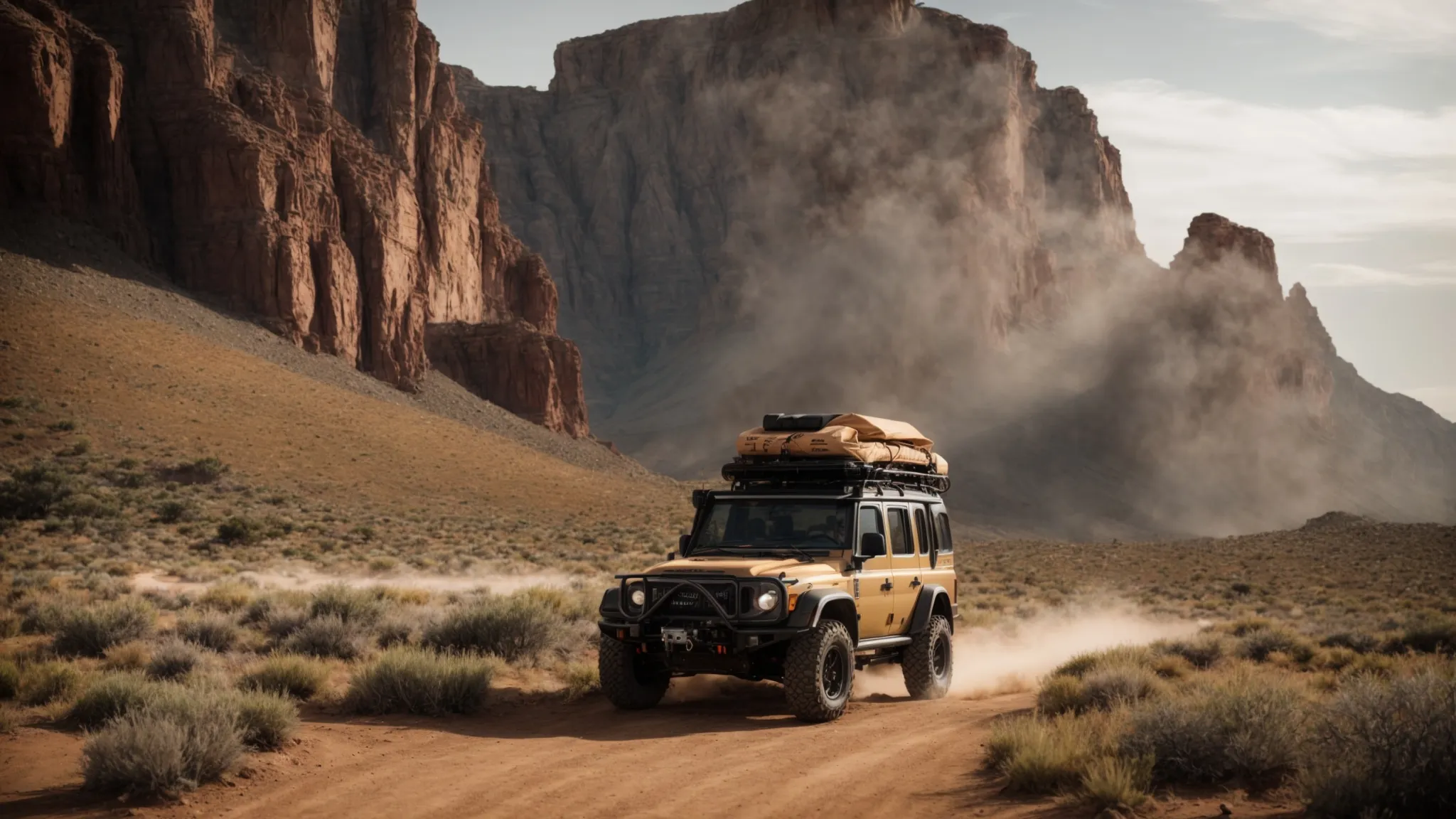 an adventurous vehicle is parked beside a rugged off-road trailer, both poised at the start of a dusty trail leading into a wild, untamed landscape.