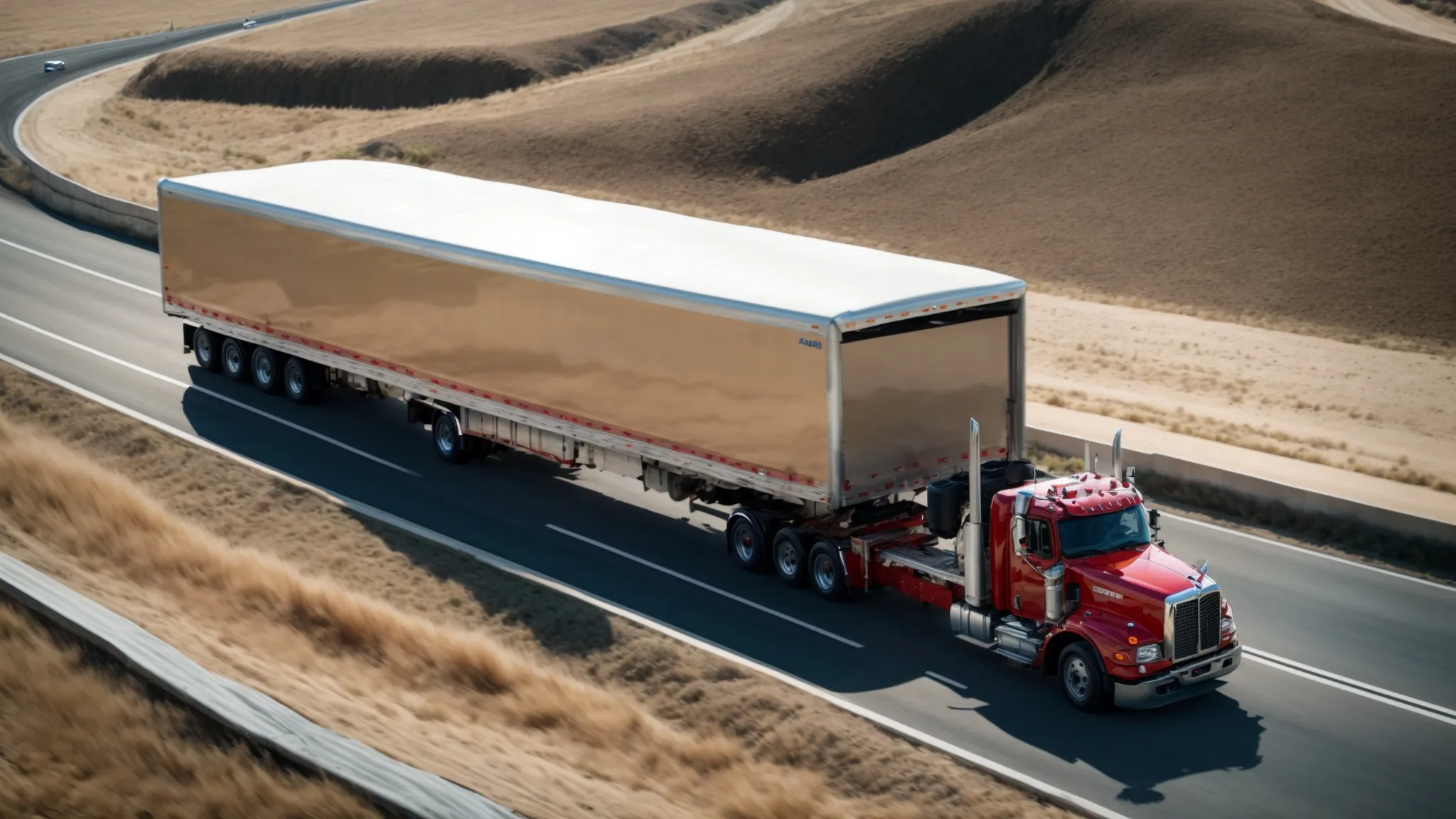 a truck towing a large trailer moves confidently across a wide, empty highway, under a clear blue sky.