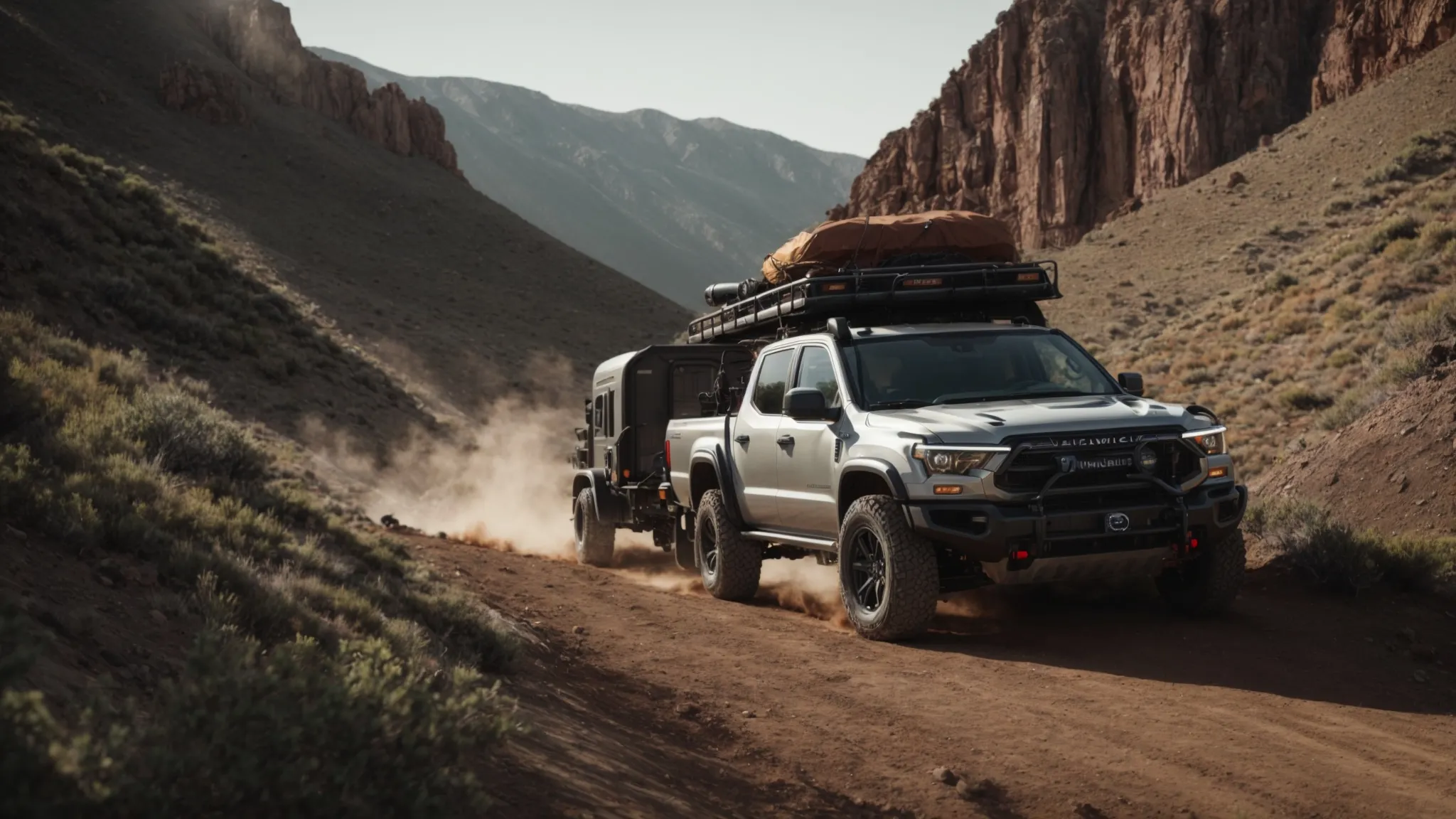 a vehicle towing an off-road trailer cautiously climbs a steep, rocky incline amidst a rugged landscape.